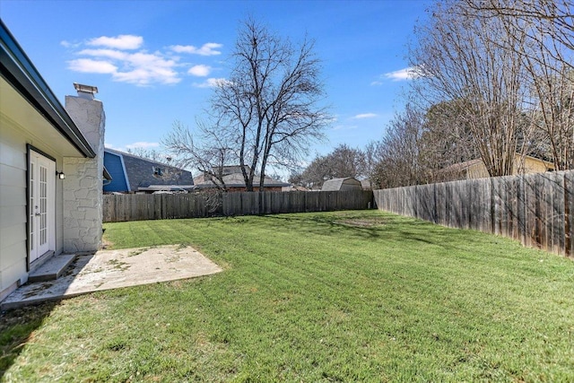 view of yard featuring a patio, french doors, and a fenced backyard