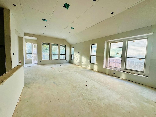 unfurnished room with vaulted ceiling