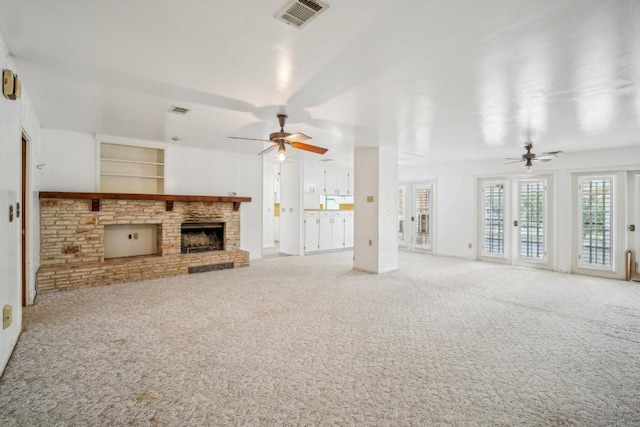 unfurnished living room featuring visible vents, a brick fireplace, a ceiling fan, and carpet floors