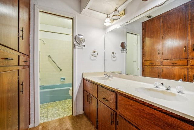 full bath with a sink, visible vents, toilet, and double vanity