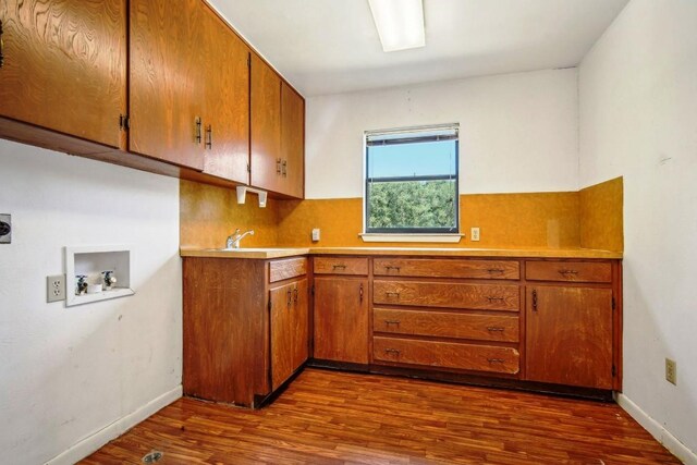 kitchen with dark wood-style floors, brown cabinets, light countertops, and baseboards