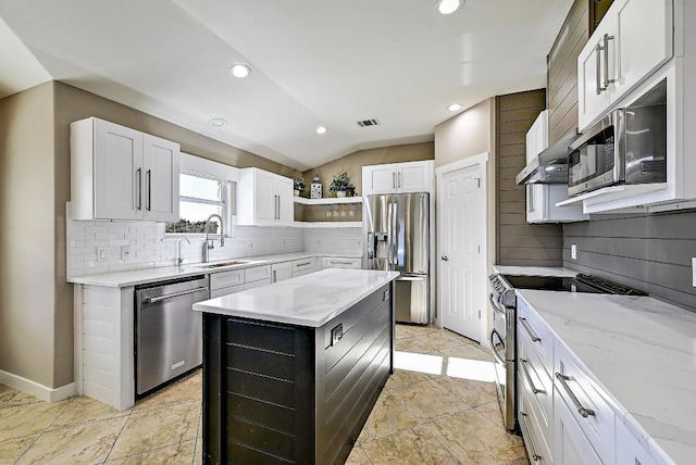 kitchen with open shelves, light stone counters, a sink, a kitchen island, and stainless steel appliances