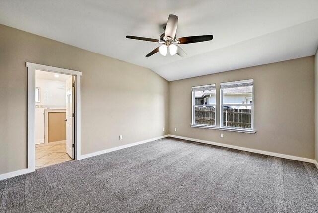 carpeted spare room featuring ceiling fan, baseboards, and lofted ceiling