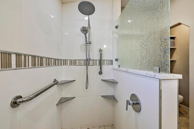 bathroom featuring toilet and a tile shower