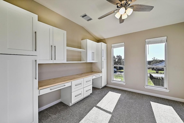 unfurnished office with visible vents, baseboards, ceiling fan, lofted ceiling, and built in study area