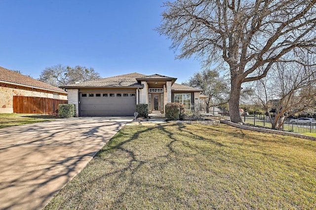 view of front of property with a front lawn, concrete driveway, a garage, and fence