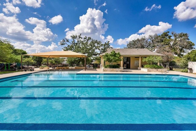 pool with a patio area and fence