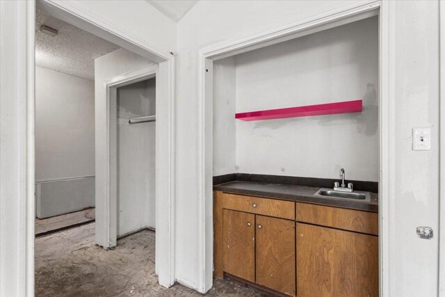 interior space with a sink, wet bar, and a textured ceiling