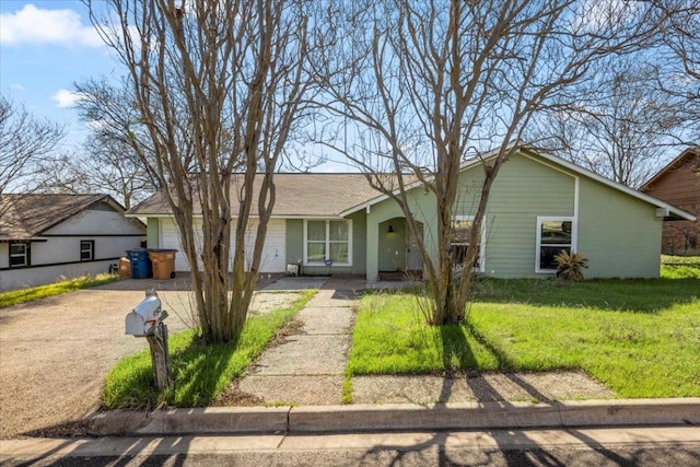 ranch-style home with a garage, a front yard, and driveway