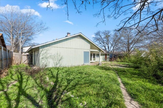 rear view of property with a chimney and fence