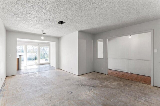 spare room featuring a textured ceiling and concrete flooring