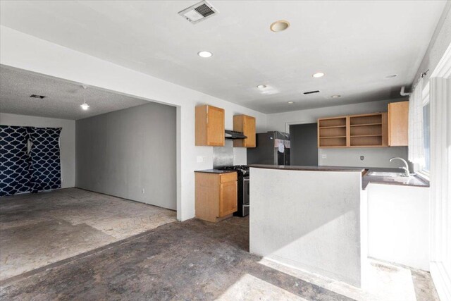 kitchen featuring visible vents, stainless steel gas range, open shelves, freestanding refrigerator, and a sink