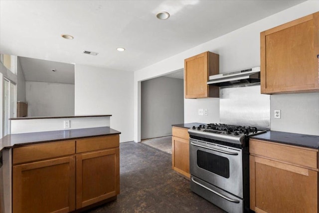 kitchen with under cabinet range hood, visible vents, gas range, and dark countertops