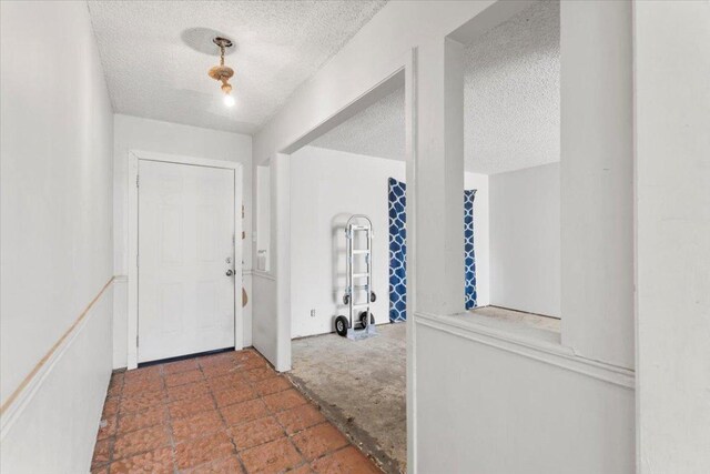 carpeted entrance foyer featuring a textured ceiling