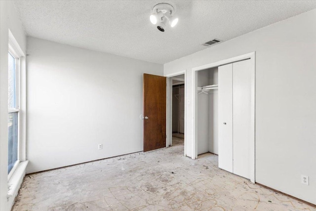 unfurnished bedroom featuring visible vents, a closet, and a textured ceiling