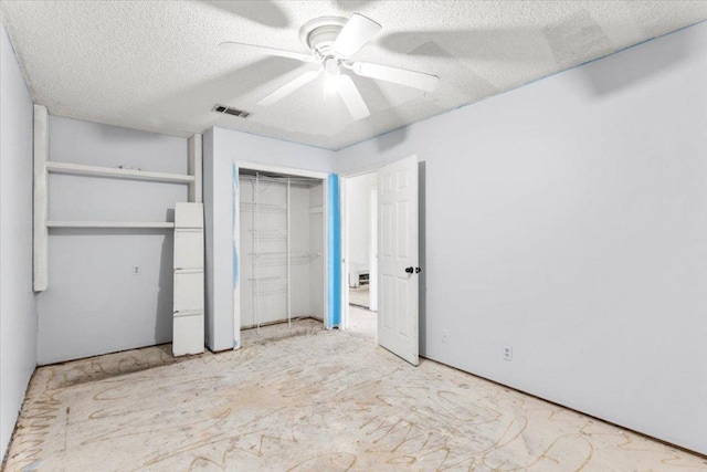 unfurnished bedroom with visible vents, a textured ceiling, and a ceiling fan