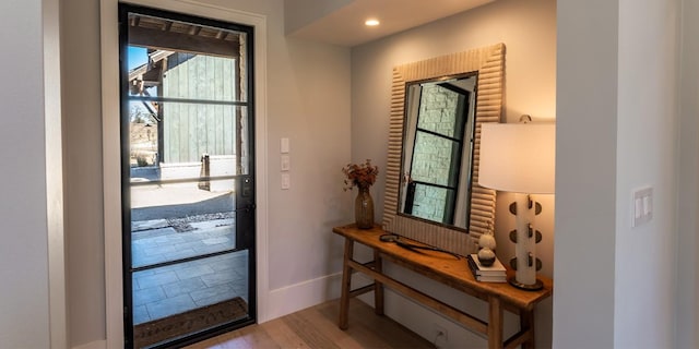 doorway with recessed lighting, baseboards, and wood finished floors