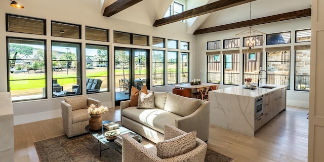 sunroom / solarium featuring a sink, lofted ceiling with beams, and a wealth of natural light