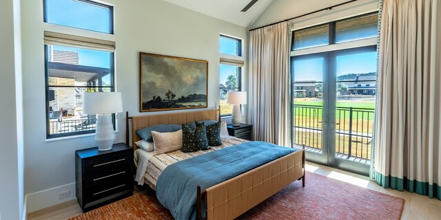 bedroom featuring access to outside, multiple windows, french doors, and high vaulted ceiling