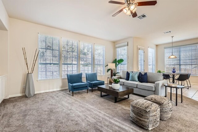 tiled living area featuring visible vents, baseboards, and a ceiling fan