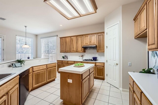 kitchen featuring under cabinet range hood, gas cooktop, backsplash, black dishwasher, and light countertops