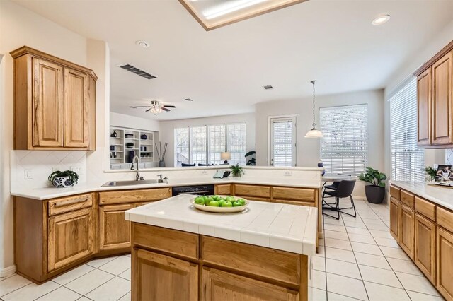 kitchen with visible vents, a sink, tasteful backsplash, a center island, and light tile patterned floors