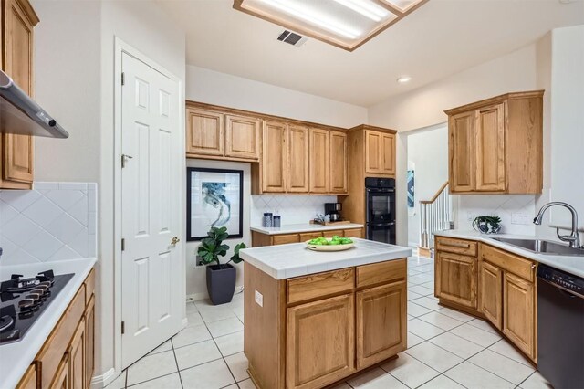 kitchen featuring light tile patterned flooring, a sink, black appliances, light countertops, and a center island