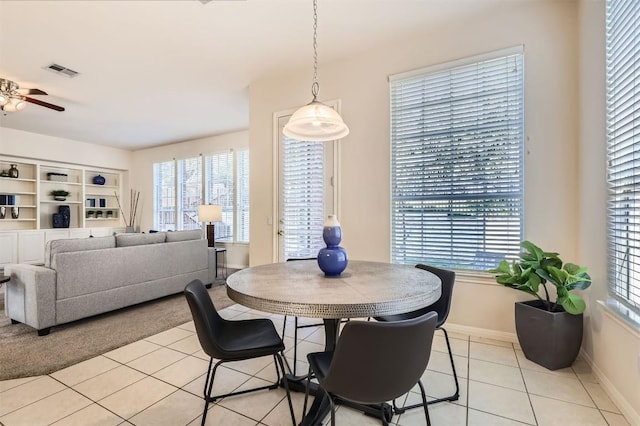 dining area featuring light tile patterned flooring, visible vents, baseboards, and a ceiling fan