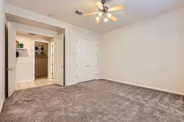 unfurnished bedroom with tile patterned floors, visible vents, baseboards, and carpet