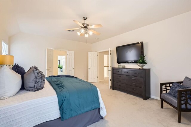 bedroom featuring light carpet, baseboards, lofted ceiling, and a ceiling fan