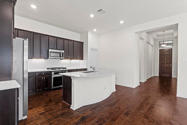 kitchen featuring visible vents, dark wood-type flooring, dark brown cabinetry, appliances with stainless steel finishes, and decorative backsplash