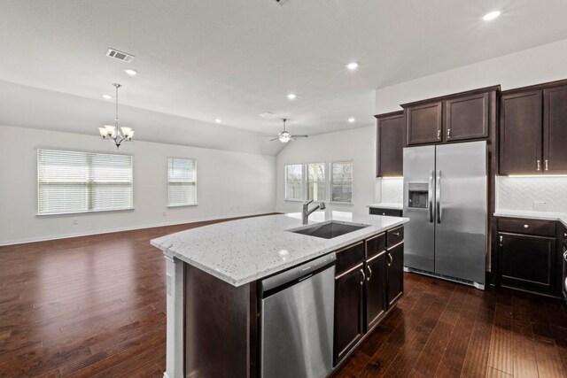 kitchen featuring vaulted ceiling, tasteful backsplash, open floor plan, and appliances with stainless steel finishes