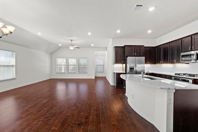 kitchen with visible vents, a sink, decorative backsplash, stainless steel appliances, and open floor plan