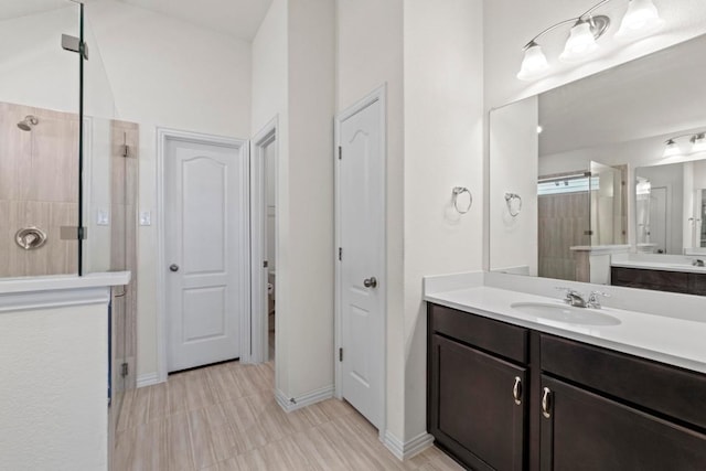 bathroom with a shower stall, vanity, and baseboards