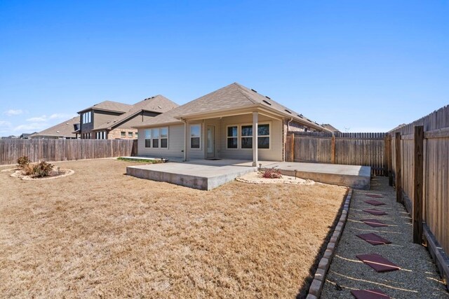 back of property with a patio, a yard, and a fenced backyard