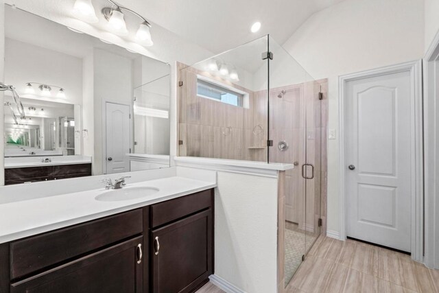 full bathroom with lofted ceiling, vanity, and a shower stall