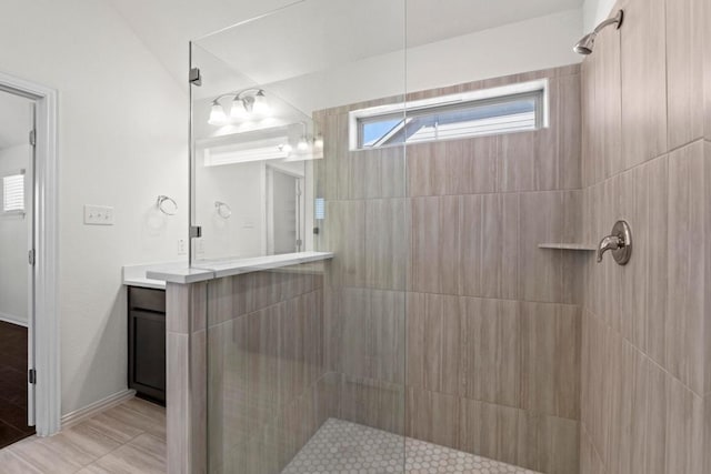 full bathroom with tiled shower and vanity