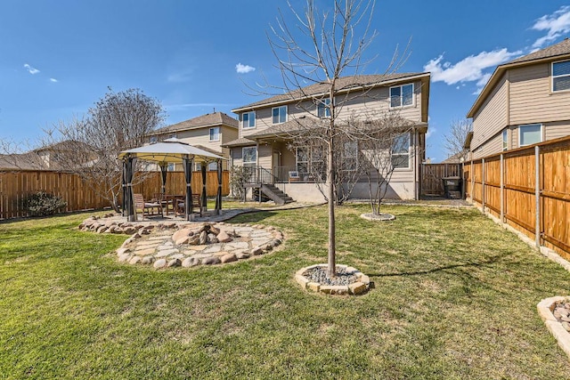 rear view of property with a gazebo, a patio area, a lawn, and a fenced backyard