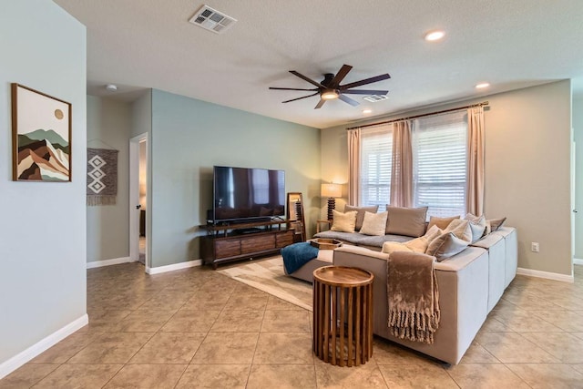 living area with visible vents, light tile patterned flooring, and a ceiling fan