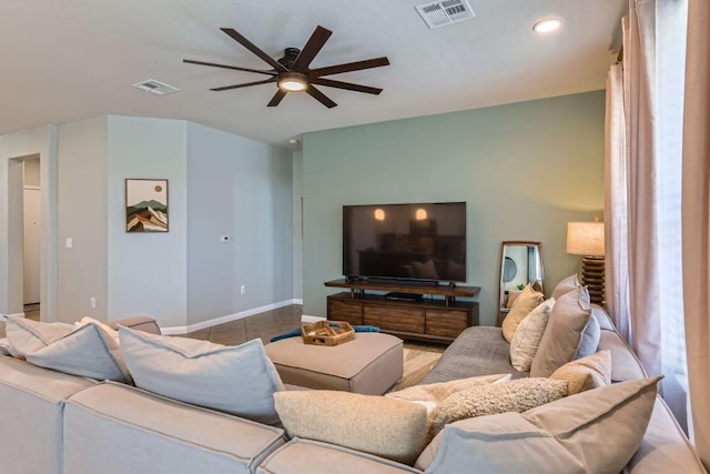 living area featuring visible vents, baseboards, and a ceiling fan