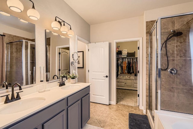 bathroom with a sink, a spacious closet, and a shower stall