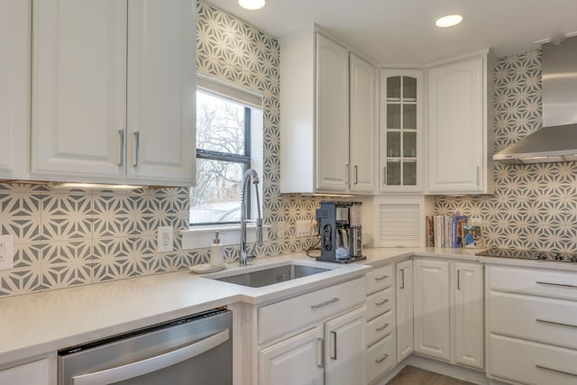 kitchen featuring a sink, stainless steel dishwasher, white cabinetry, wall chimney exhaust hood, and black electric cooktop