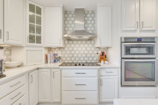 5400 Grover Ave, Austin, TX 78756 - kitchen featuring double oven, white cabinetry, decorative backsplash, wall chimney exhaust hood, and black electric cooktop