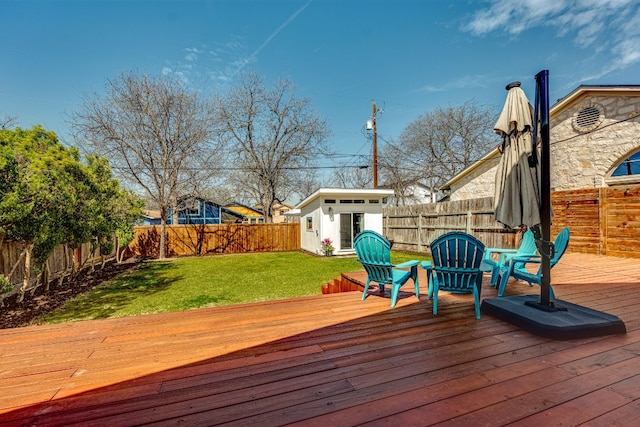 deck with an outbuilding, a yard, and a fenced backyard