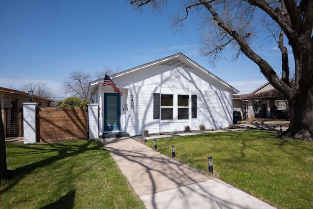 view of front of property featuring a front lawn and fence