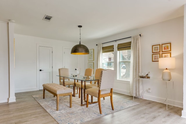 dining area with visible vents, baseboards, and light wood-style floors