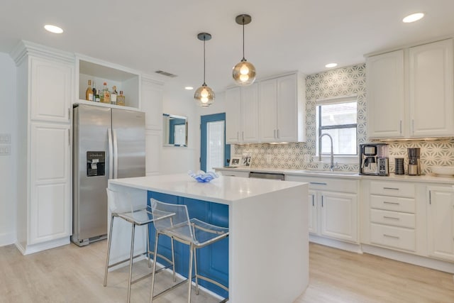 kitchen featuring a sink, light wood-style floors, white cabinets, stainless steel appliances, and open shelves