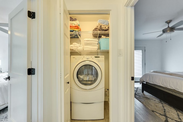 laundry room with a ceiling fan, washer / dryer, wood finished floors, and laundry area