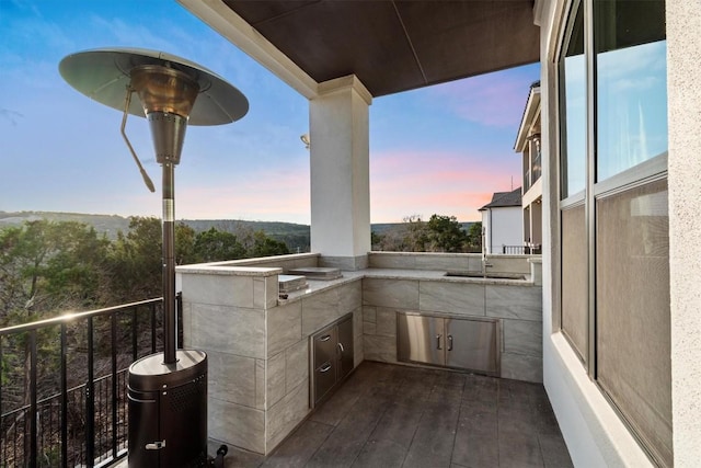 balcony at dusk with exterior kitchen