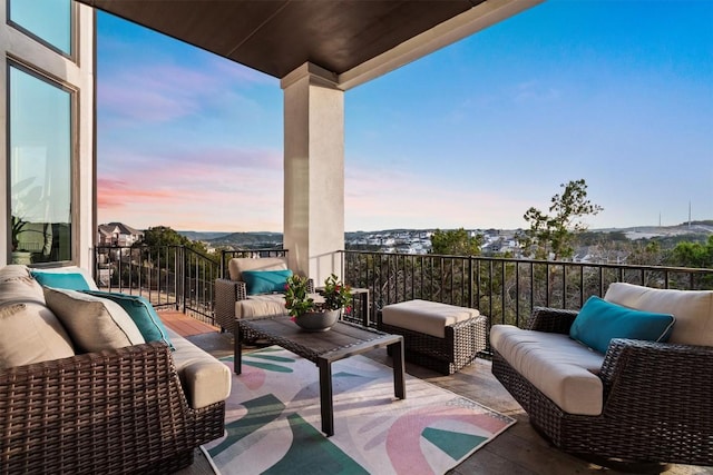 balcony at dusk featuring an outdoor living space